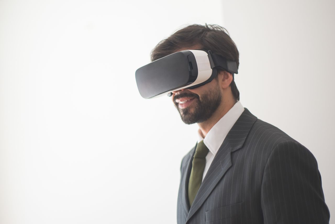 Professional man in a suit exploring virtual reality with VR glasses. Modern and innovative tech experience.